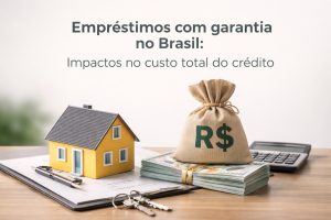 Modelo de casa amarela sobre documentos financeiros ao lado de um saco de dinheiro com símbolo R$ e pilha de notas de real, com calculadora ao fundo, representando emprestimos com garantia no Brasil e impacto no custo total do crédito imobiliário.